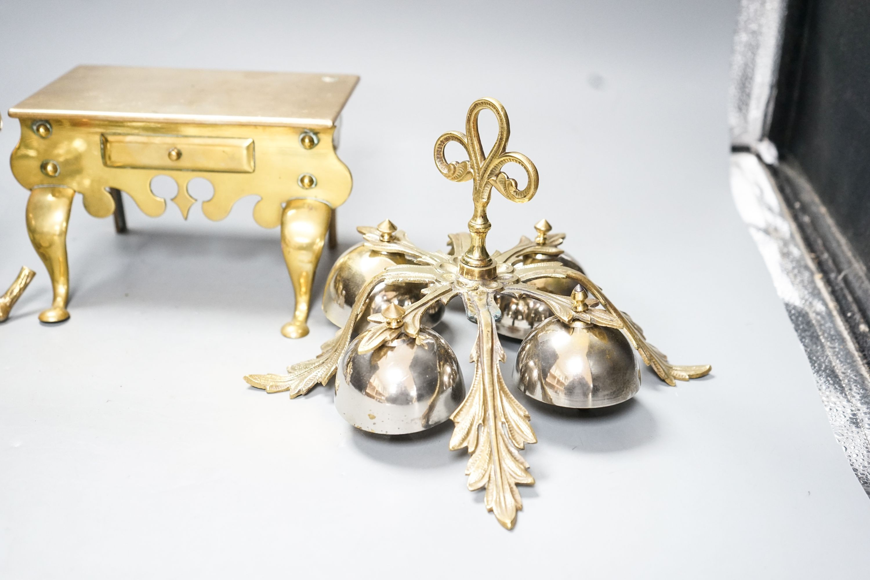 A brass Jockey-related inkwell, a miniature brass footman and brass hand bells